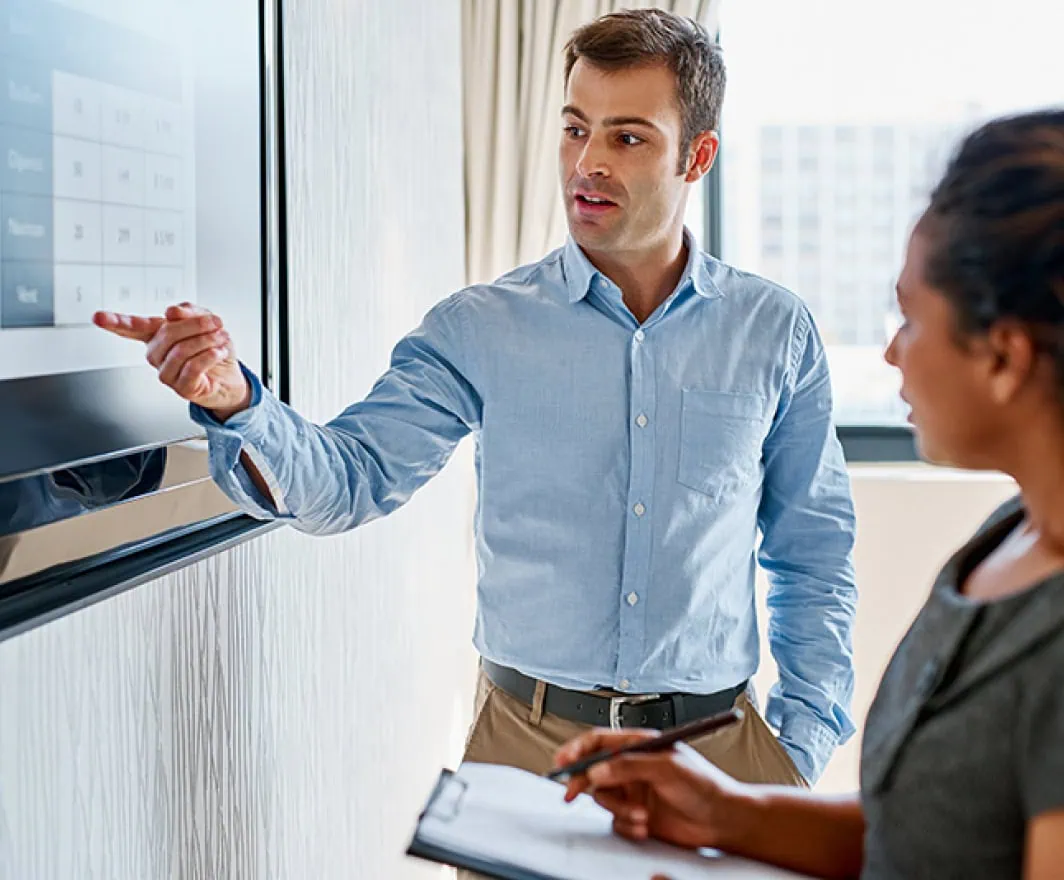 Man pointing to presentation on display in meeting